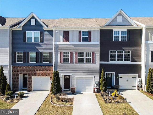 townhome / multi-family property featuring driveway and brick siding