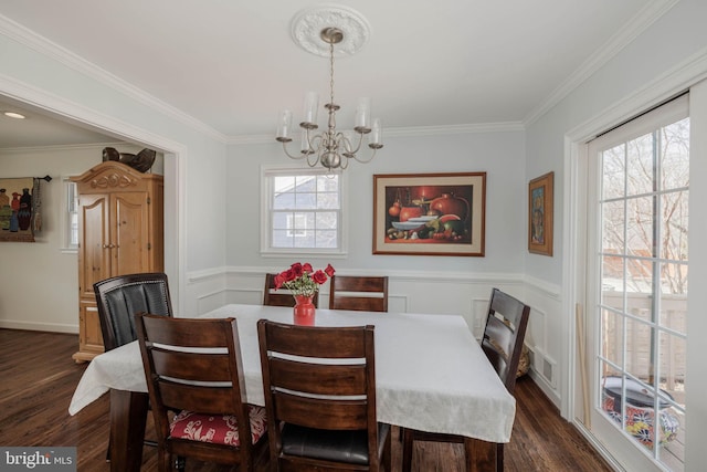 dining space featuring dark wood-style floors, a healthy amount of sunlight, and crown molding