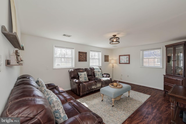 living room with dark wood-style flooring, visible vents, and baseboards