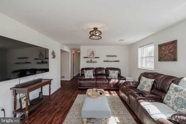 living room with wood finished floors, visible vents, and baseboards