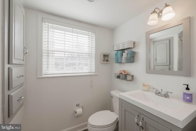 half bathroom with vanity and toilet