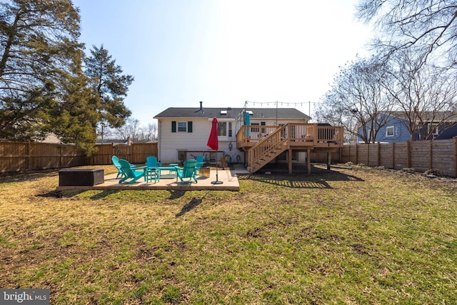 rear view of house featuring a fenced backyard, stairs, a yard, a wooden deck, and a patio area