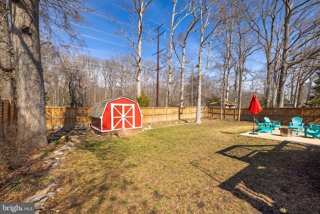 view of yard featuring an outbuilding, a fenced backyard, a patio, and a storage unit