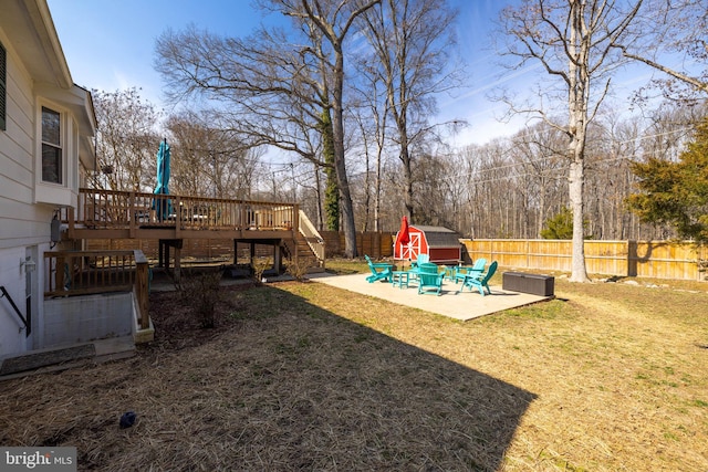 view of yard featuring an outbuilding, a patio, stairway, a fenced backyard, and a wooden deck