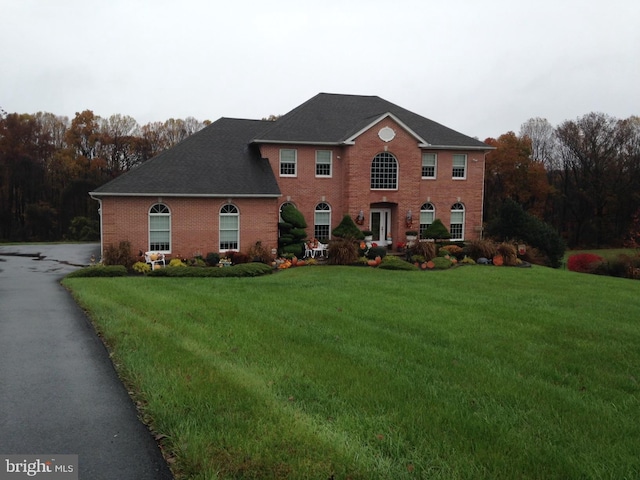 view of front of house featuring a front lawn and brick siding