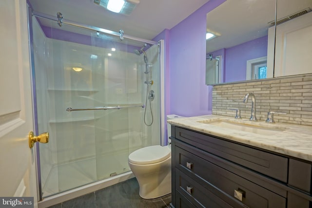 bathroom with vanity, a stall shower, backsplash, and toilet