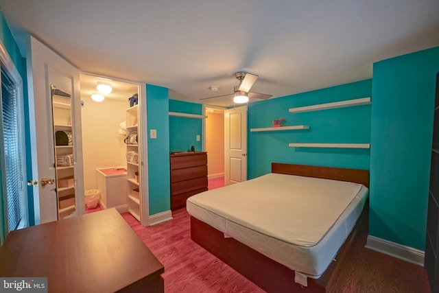 bedroom featuring a closet, wood finished floors, a ceiling fan, and baseboards