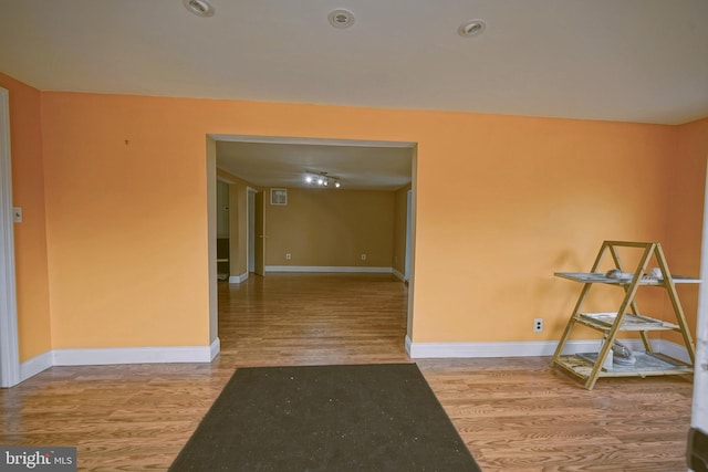 empty room featuring wood finished floors and baseboards