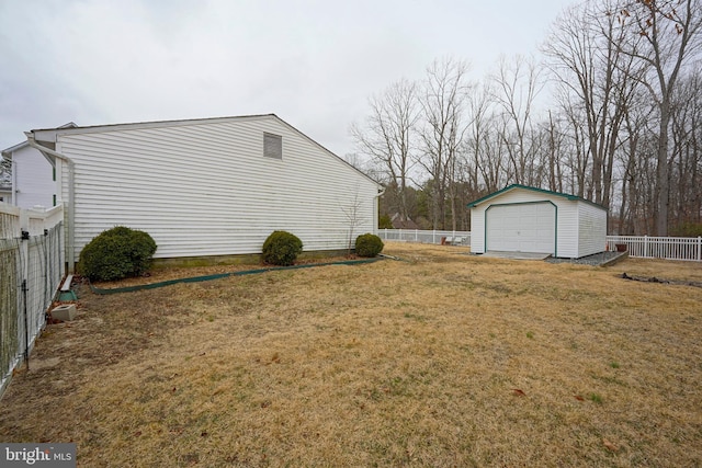 view of yard featuring a fenced backyard, an outdoor structure, and a detached garage