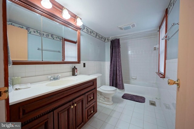 full bath with tile patterned flooring, toilet, visible vents, vanity, and tile walls