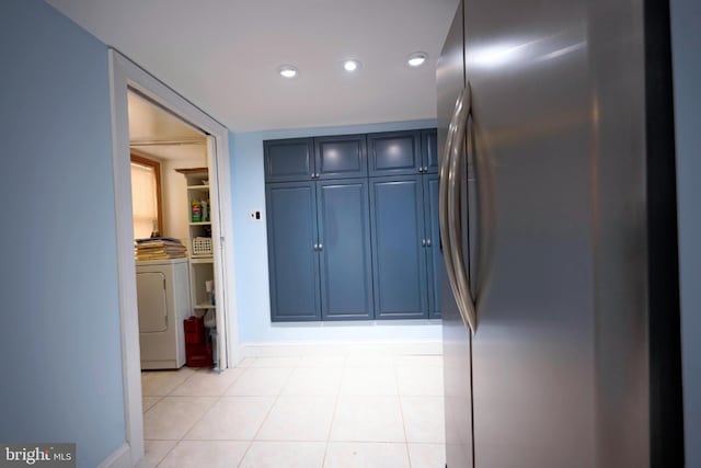 hallway featuring baseboards, washer and clothes dryer, light tile patterned flooring, and recessed lighting