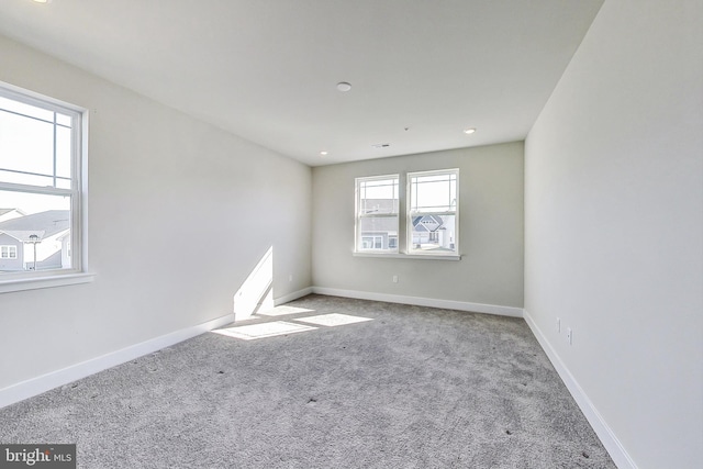 carpeted spare room featuring baseboards