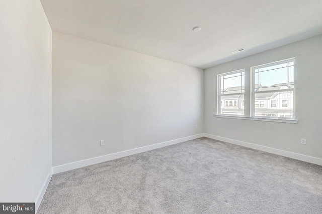 spare room featuring carpet floors and baseboards