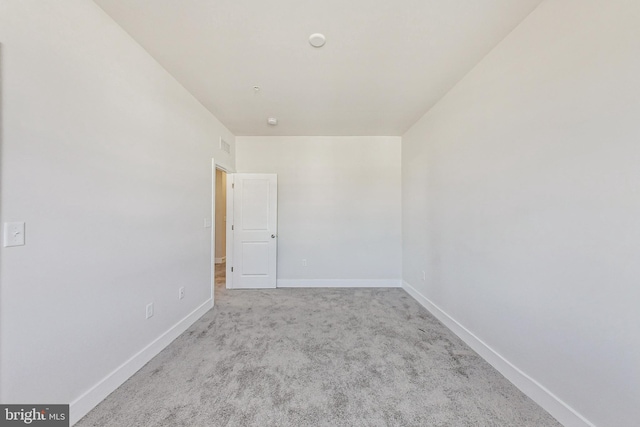 spare room with carpet and baseboards