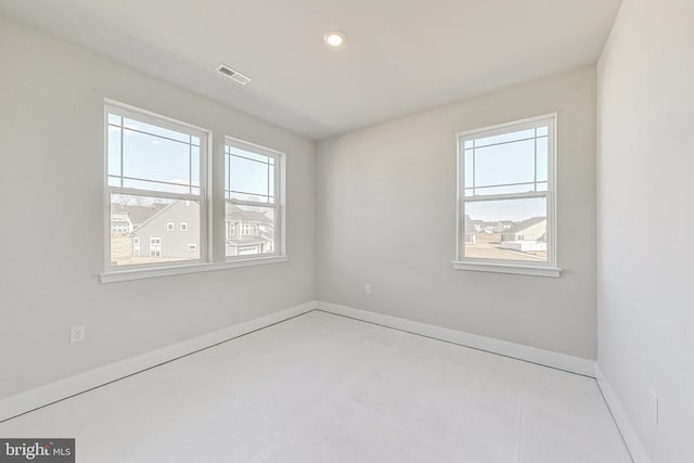 unfurnished room featuring a healthy amount of sunlight, visible vents, finished concrete flooring, and baseboards