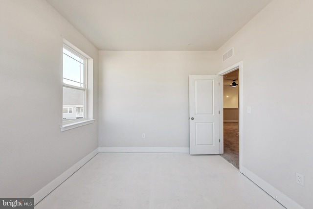 unfurnished room with baseboards, visible vents, and concrete flooring