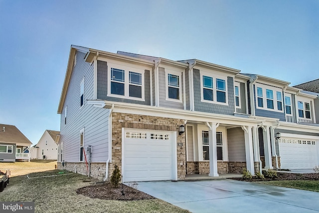 view of front of home featuring a garage, a residential view, stone siding, and driveway