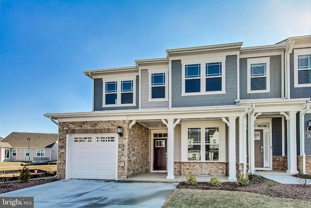 view of front of house with driveway, stone siding, and a porch