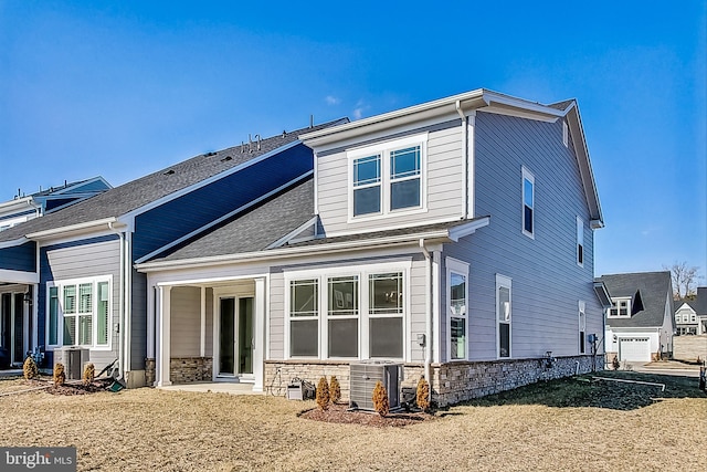 rear view of property with cooling unit and stone siding