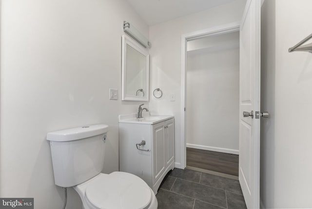 bathroom with baseboards, vanity, toilet, and tile patterned floors