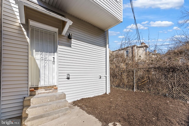 doorway to property featuring fence