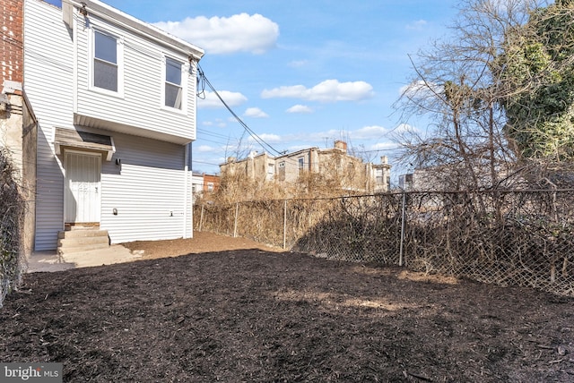 view of yard with entry steps and fence