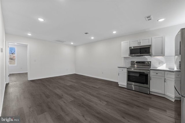 kitchen featuring dark wood-style flooring, visible vents, stainless steel appliances, and backsplash