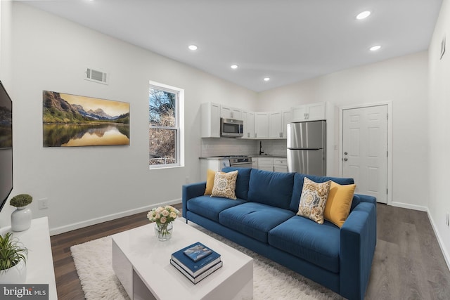 living area with recessed lighting, dark wood finished floors, visible vents, and baseboards