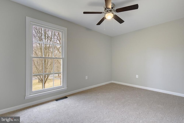 unfurnished room featuring visible vents, baseboards, carpet, and a ceiling fan