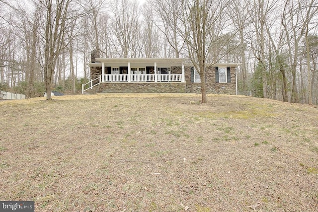 single story home featuring covered porch, stone siding, and a chimney