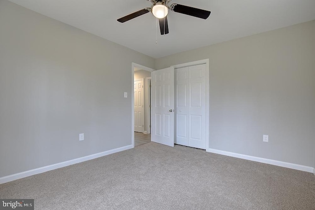 unfurnished bedroom featuring a closet, baseboards, a ceiling fan, and carpet flooring