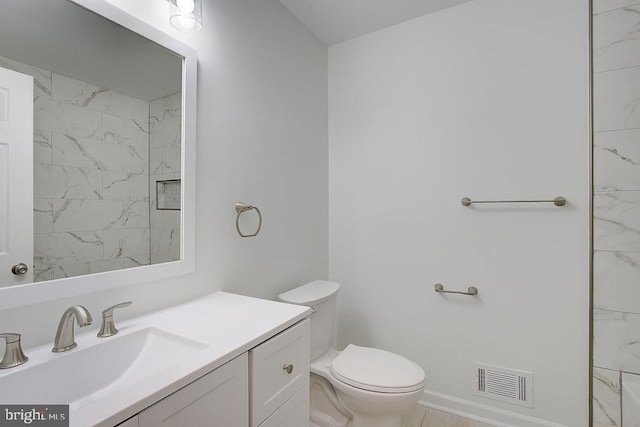 bathroom featuring visible vents, baseboards, toilet, and vanity