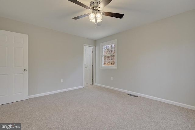 unfurnished room featuring a ceiling fan, baseboards, visible vents, and light carpet