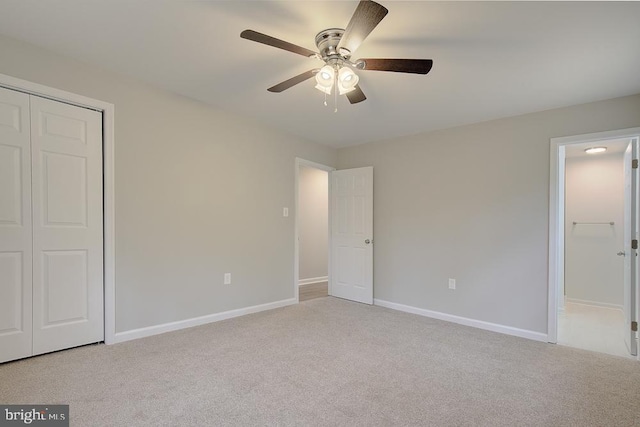 unfurnished bedroom with baseboards, carpet floors, and a closet