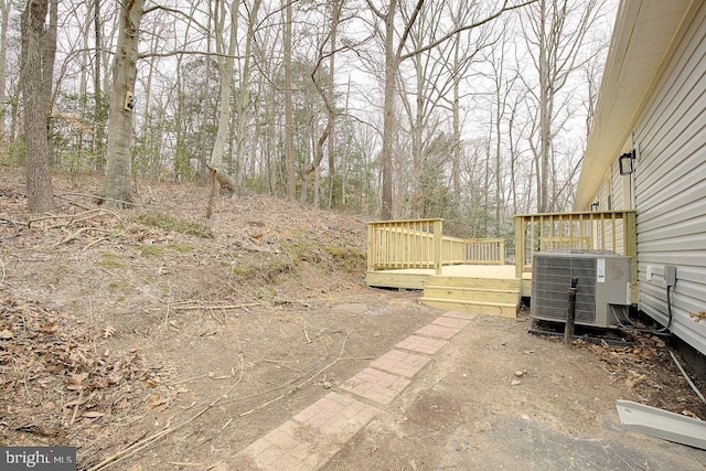 view of yard with central AC and a wooden deck