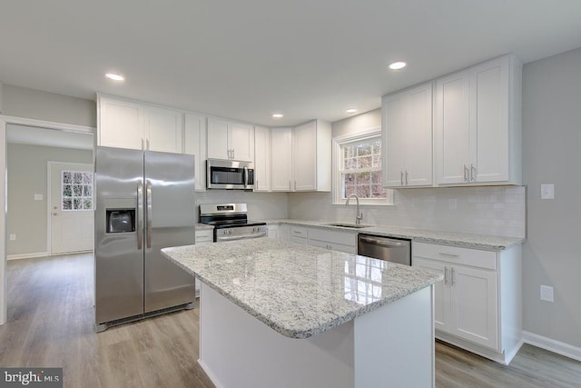 kitchen featuring tasteful backsplash, appliances with stainless steel finishes, white cabinetry, and a sink