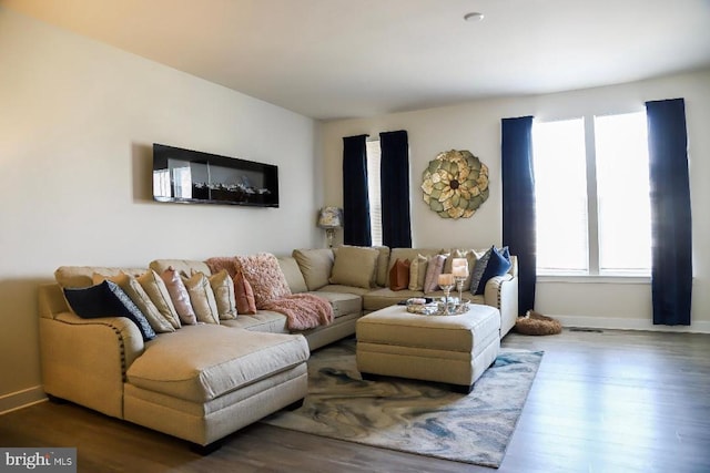 living area featuring baseboards and wood finished floors