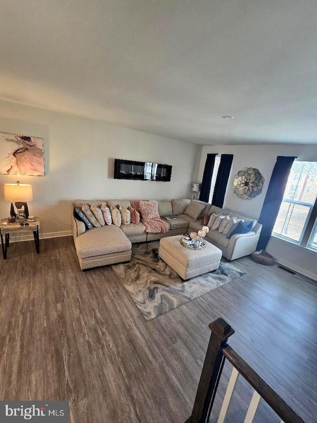 living area with visible vents, baseboards, and wood finished floors