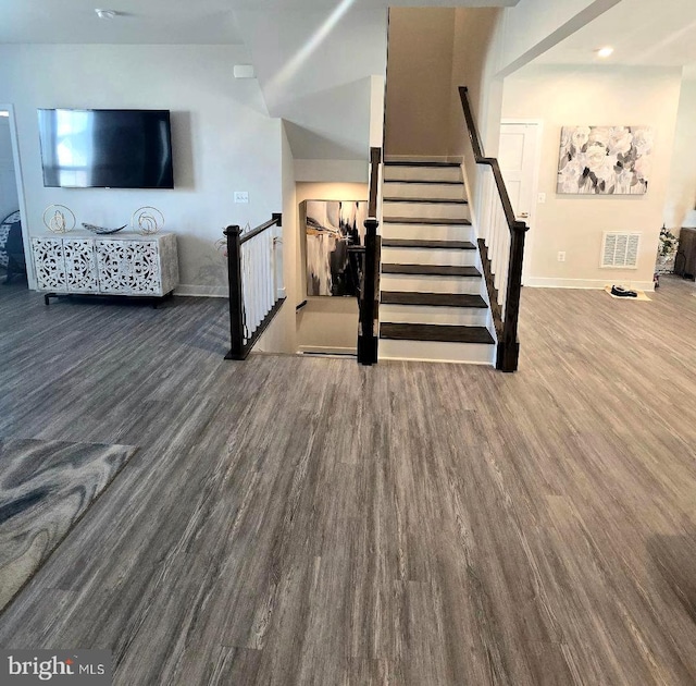 stairs featuring wood finished floors, visible vents, and baseboards