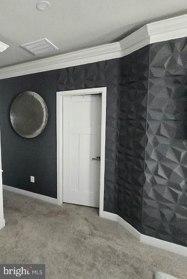 unfurnished bedroom with visible vents, carpet floors, baseboards, and crown molding