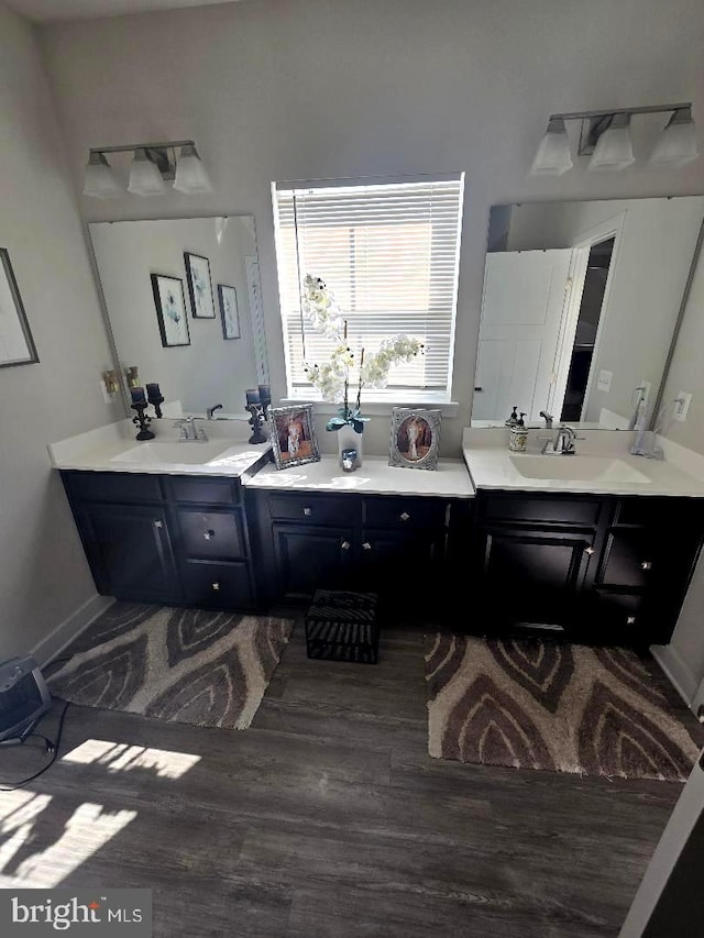 bathroom with vanity, wood finished floors, and baseboards