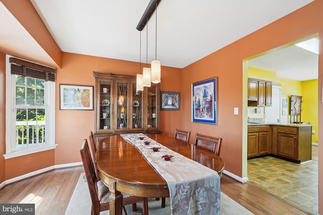 dining area with baseboards and light wood-style floors