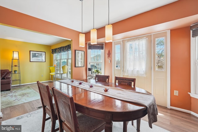 dining space with light wood-style floors and baseboards