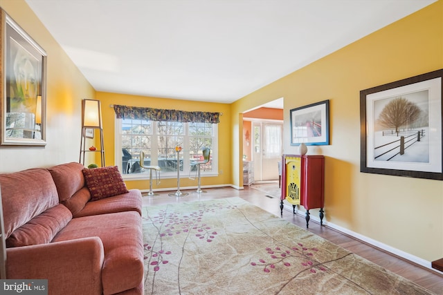 living area with baseboards and wood finished floors