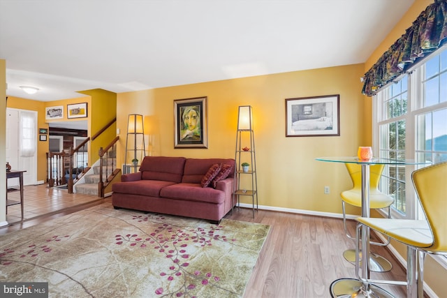 living room with stairs, wood finished floors, and baseboards