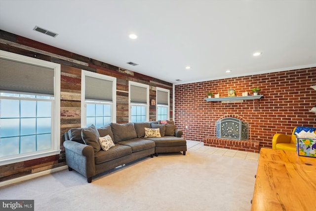 living room featuring a brick fireplace, carpet flooring, a healthy amount of sunlight, and visible vents