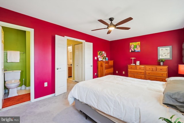 carpeted bedroom featuring a ceiling fan, baseboards, and ensuite bathroom