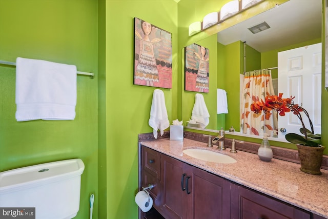 bathroom featuring curtained shower, toilet, visible vents, and vanity