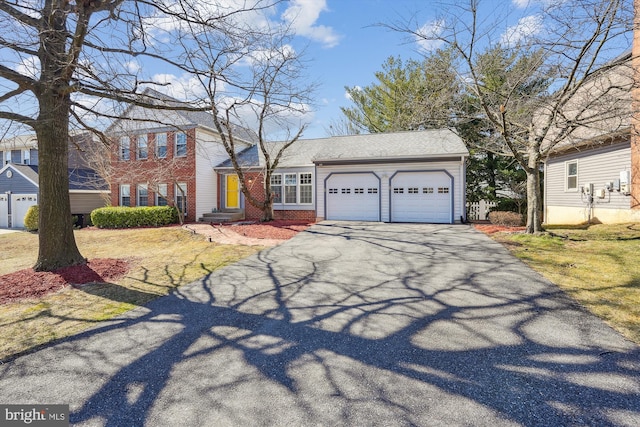 view of front of property featuring brick siding, driveway, and an attached garage