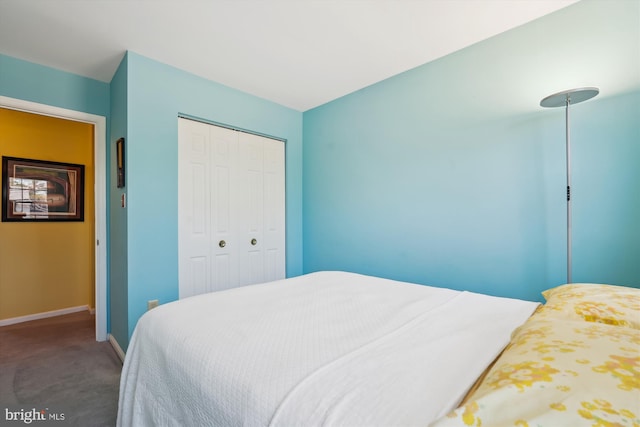 bedroom with a closet, baseboards, and carpet